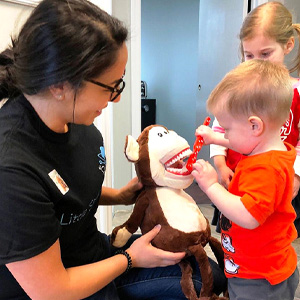 Dental Hygienist Vanessa showing on of our littlest patients the right way to brush!