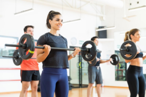 A workout class lifting weights and smiling